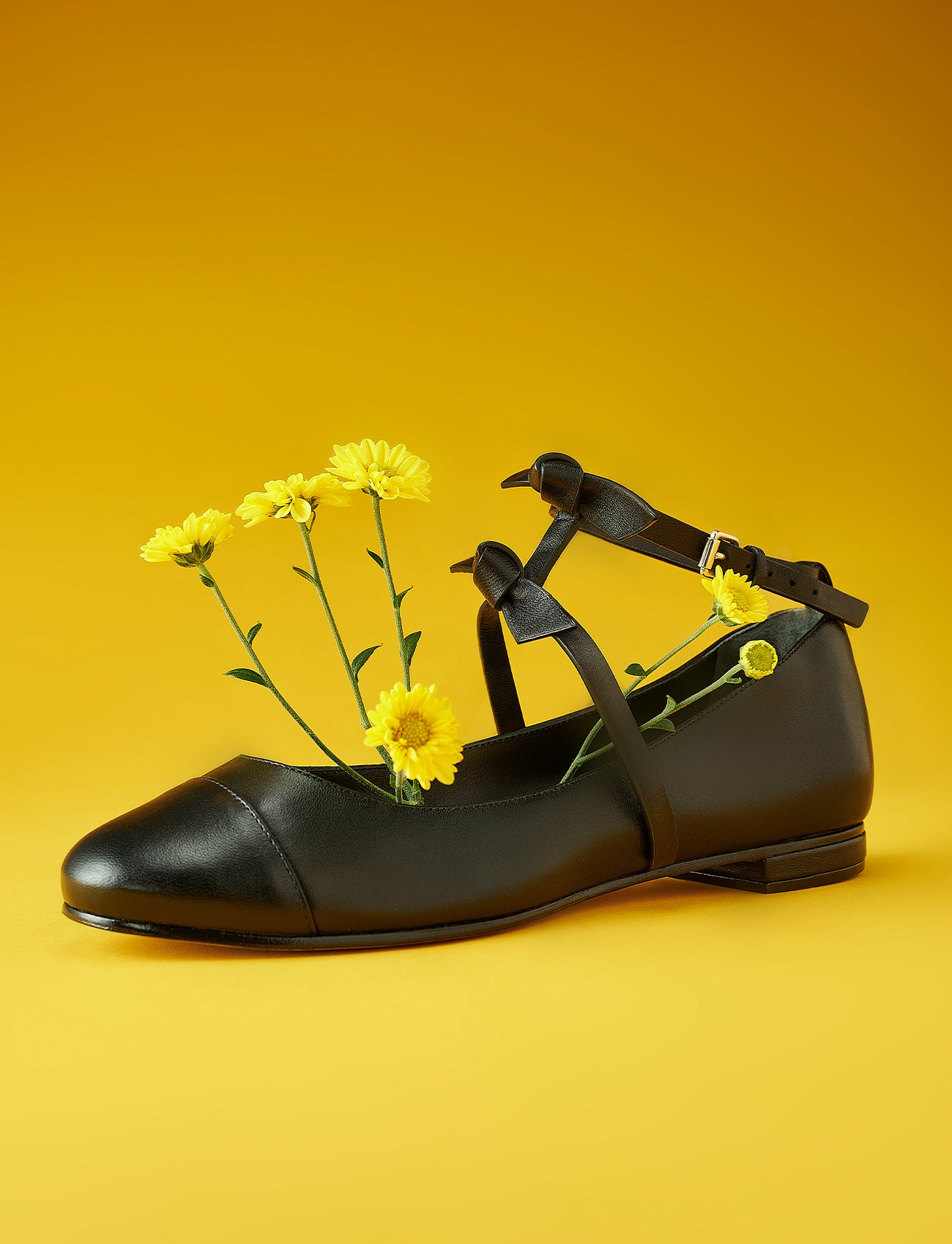 Introducing the Slim Clarita Ballet in Black. This exclusive design features elegant Clarita detailing, beautifully complemented by vibrant yellow chrysanthemum flowers against a matching background, adding a touch of artistry to your wardrobe.