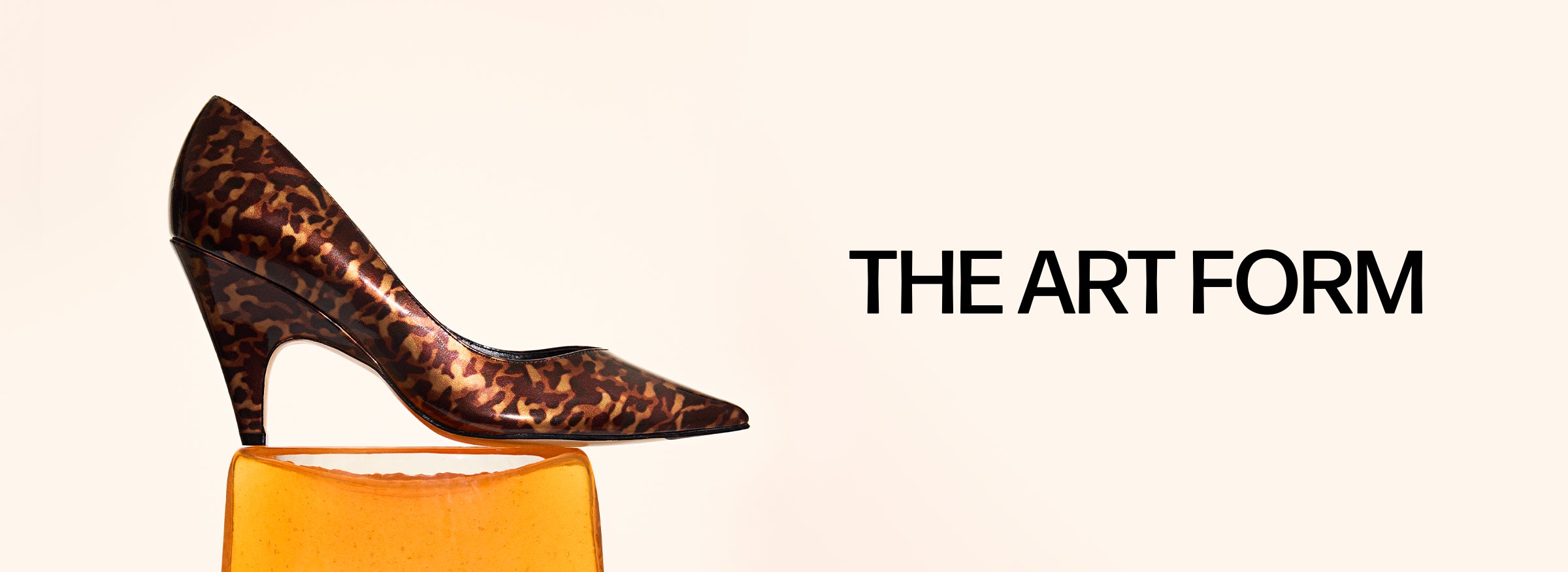  A widescreen image of a leopard-print pump with a uniquely sculpted heel, standing on an orange block. The text "THE ART FORM" is on the right.