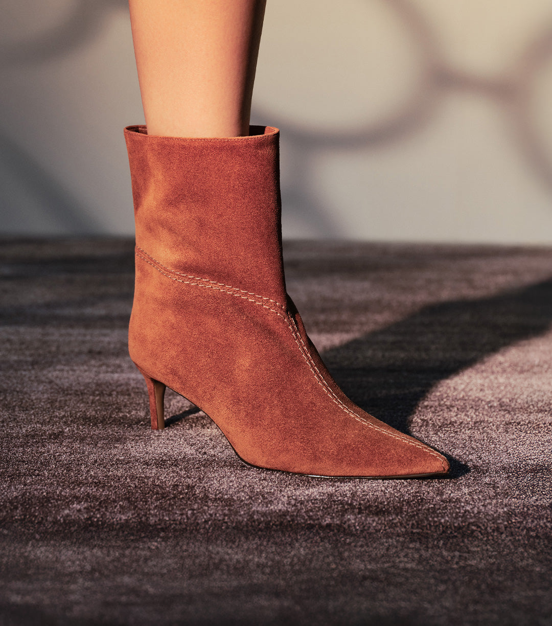 A close-up of a person's feet on a dark staircase, wearing a pair of high-platform ivory or white heels with an ankle strap.