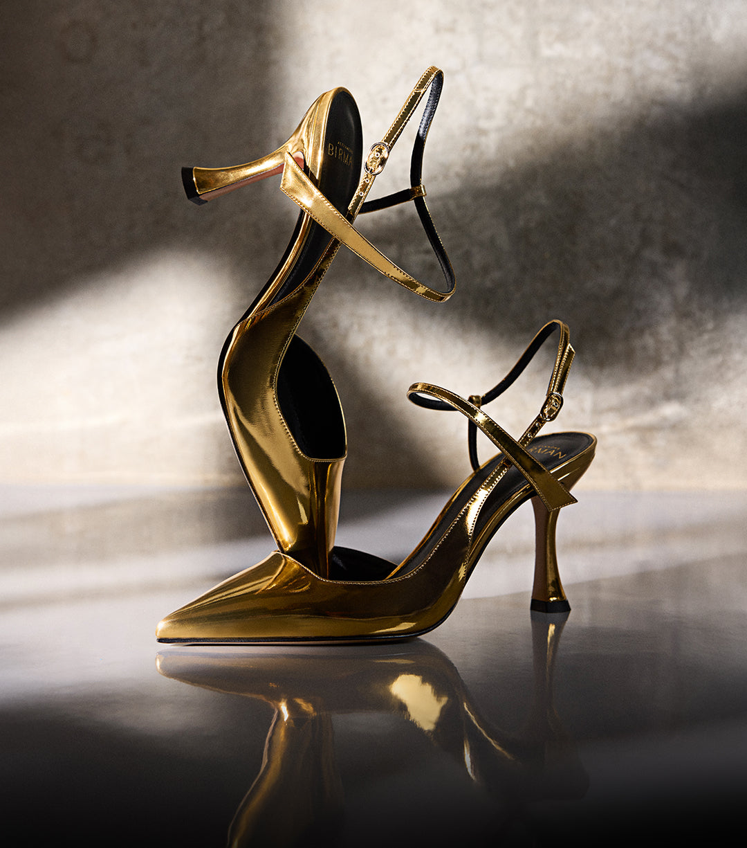 Gold metallic high-heeled pumps with ankle straps displayed under soft light against a neutral background. Text on image reads ‘New Pumps.’
