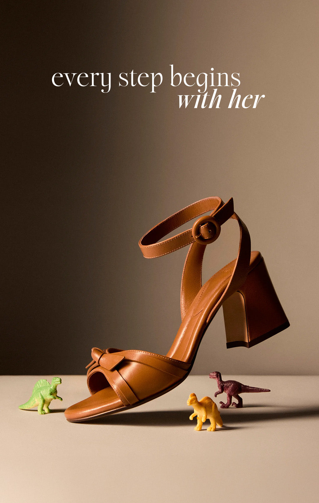  A woman in a white blouse gazes softly, her chin resting on a table with colorful toy figures. A brown sandal is on the right. Text reads "every step begins with her. Tap to shop
