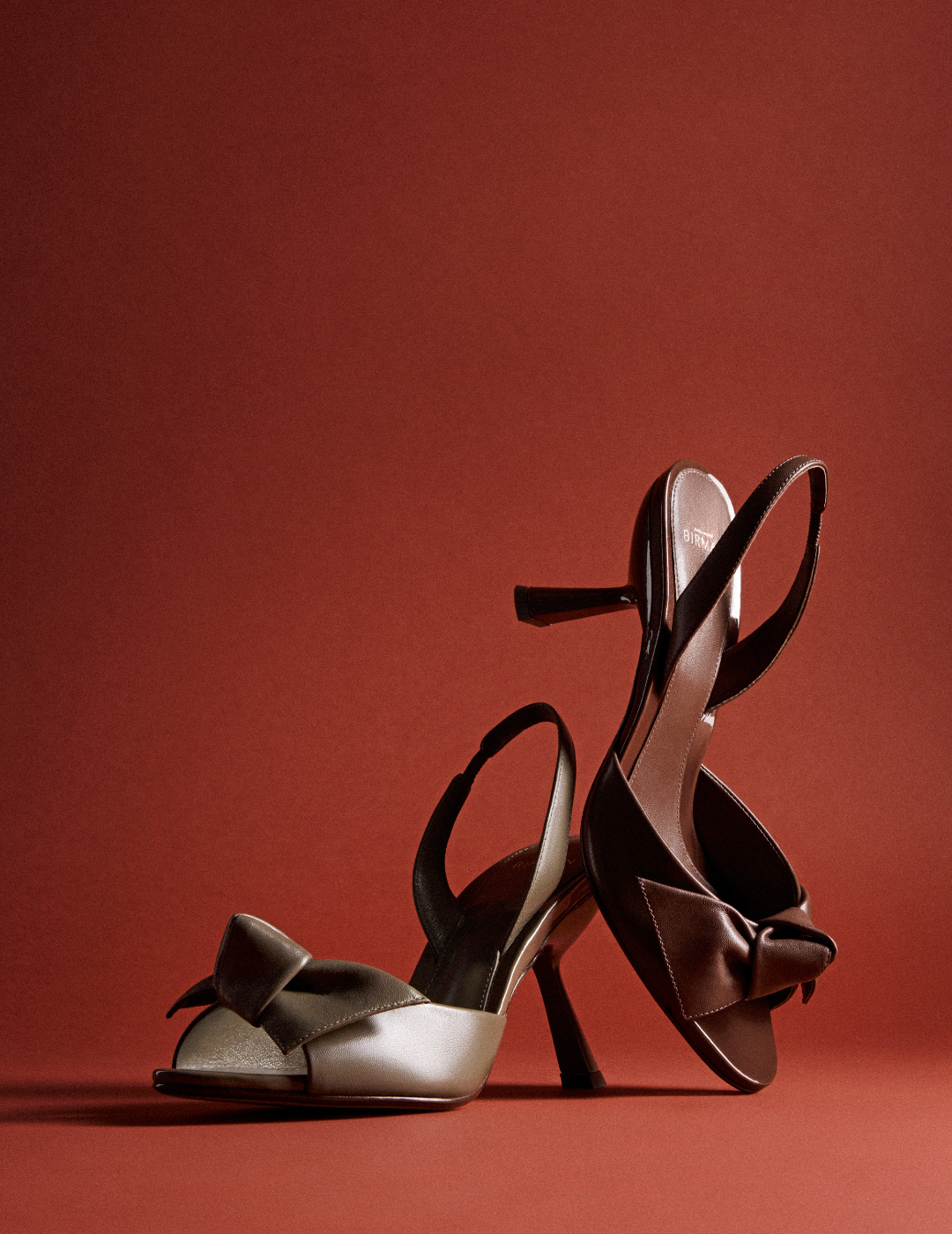 Kitten Heel Elegance: Woman in black dress showcasing Vicky City 60 Mule Black with sculptural flared heel. Explore New Arrivals in Pre-Fall.