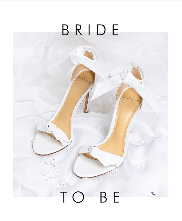 Luxury Bridal Elegance: Close-up of Clarita 75 White on white silk fabric, text reads 'BRIDE TO BE.' Celebrate love and luxury with these exquisite wedding sandals.