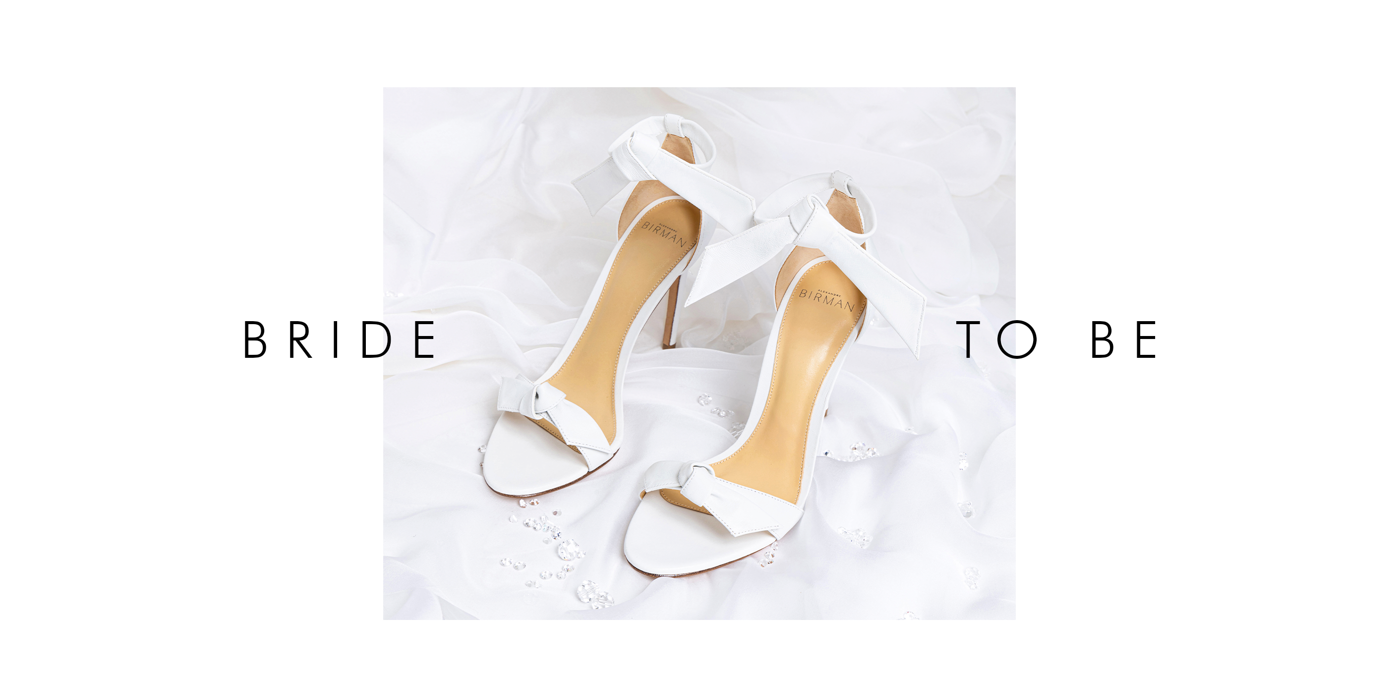 Luxury Bridal Elegance: Close-up of Clarita 75 White on white silk fabric, text reads 'BRIDE TO BE.' Celebrate love and luxury with these exquisite wedding sandals.